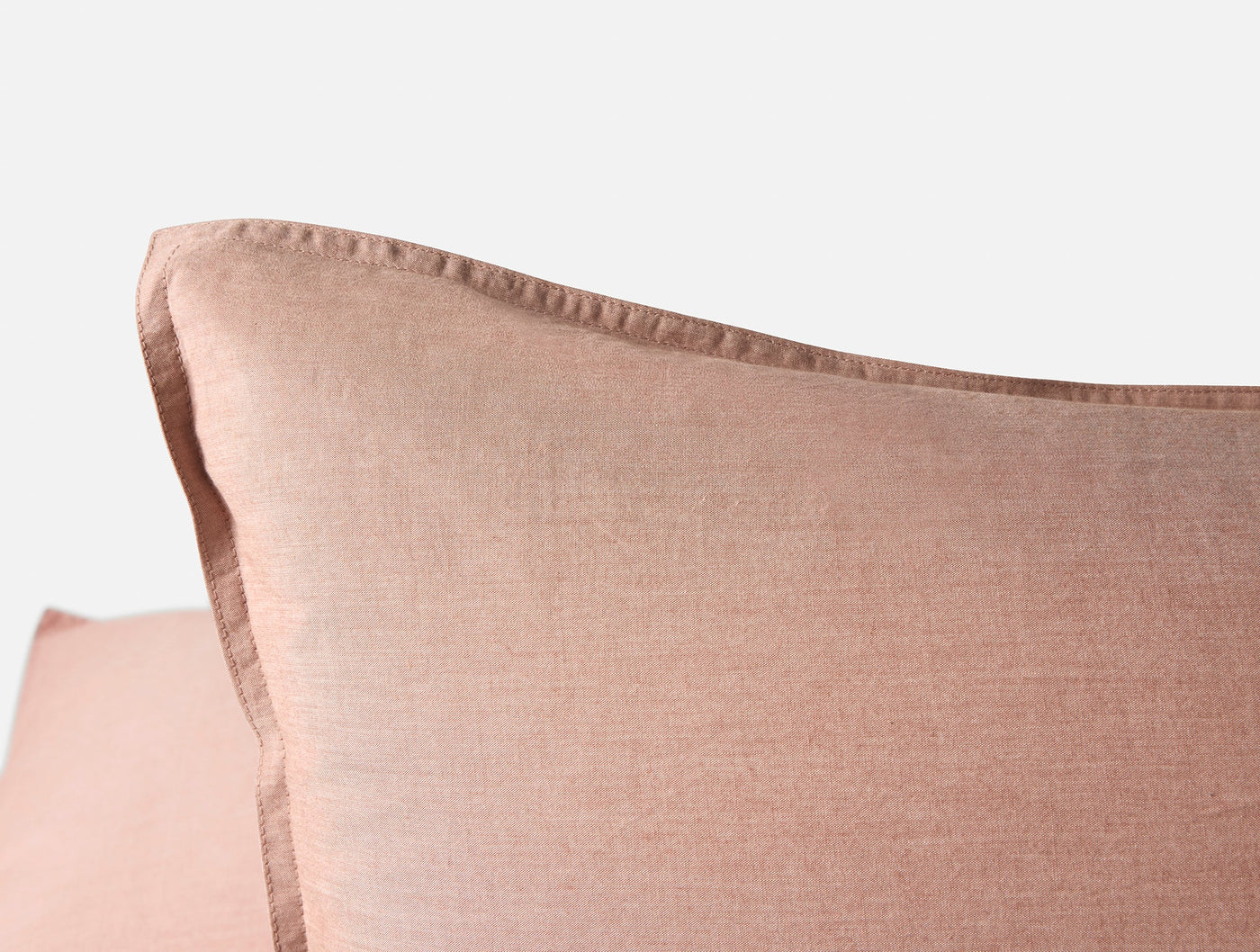 Close-up of dusty rose crinkled percale pillow sham corner with relaxed flange detail.