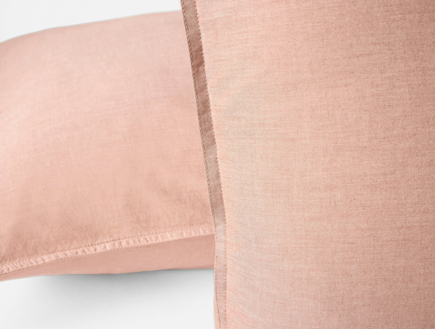 Close-up of blush Coyuchi Crinkled Percale sham showing hem stitching detail.