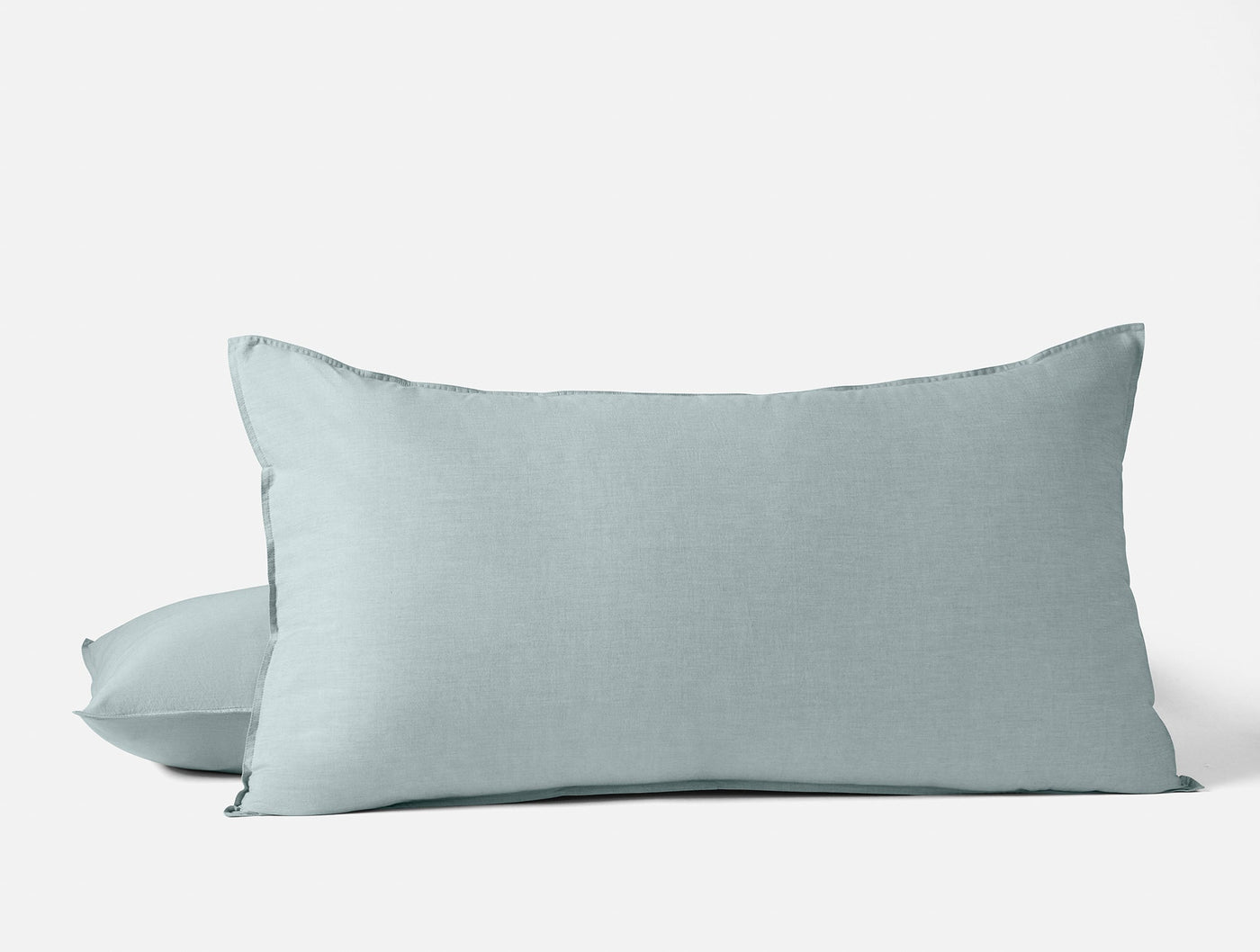 Close-up of two stacked Coyuchi Crinkled Percale shams in muted seafoam blue.