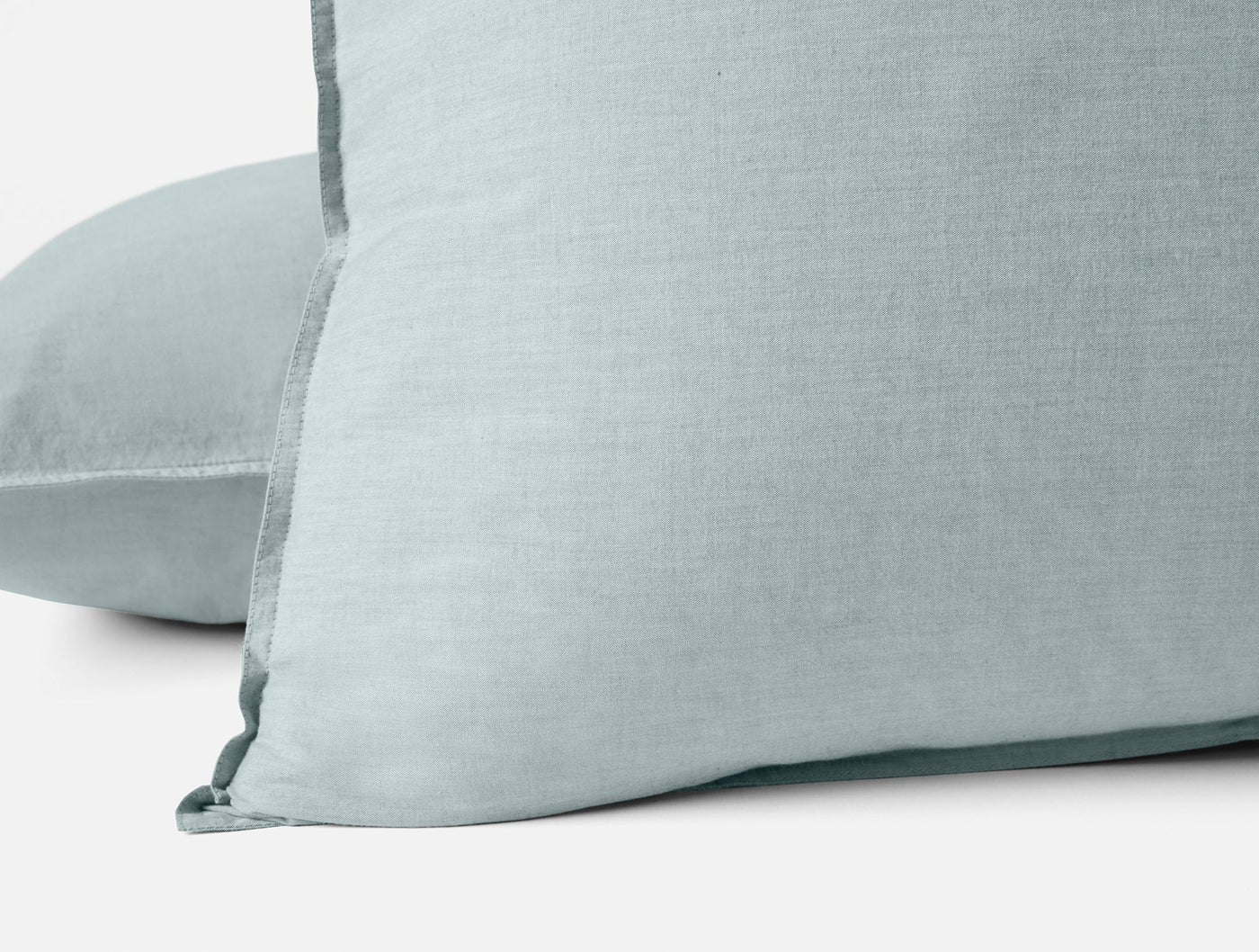 Close-up of Coyuchi Crinkled Percale sham corner in mist blue, showing relaxed texture and trim detail.