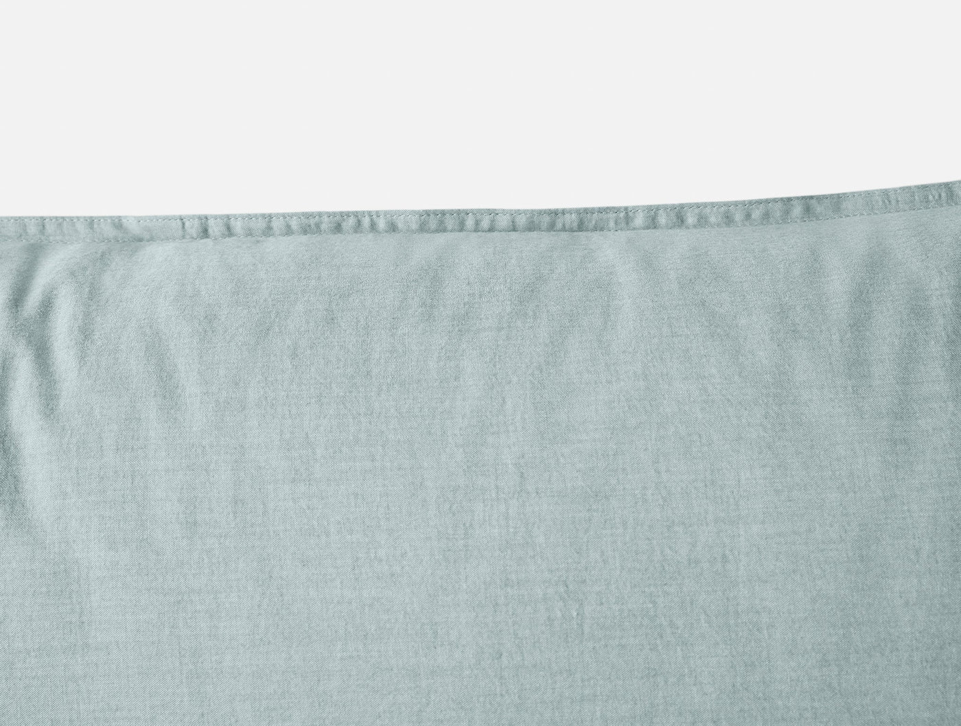 Close-up of Coyuchi Crinkled Percale sham in mist blue, showing hem stitching and relaxed texture.