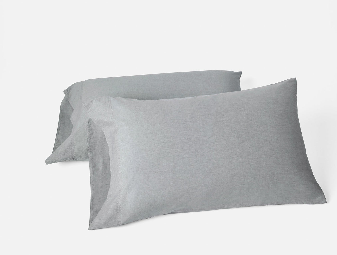 Two slate grey crinkled percale pillowcases stacked at an angle on white background.