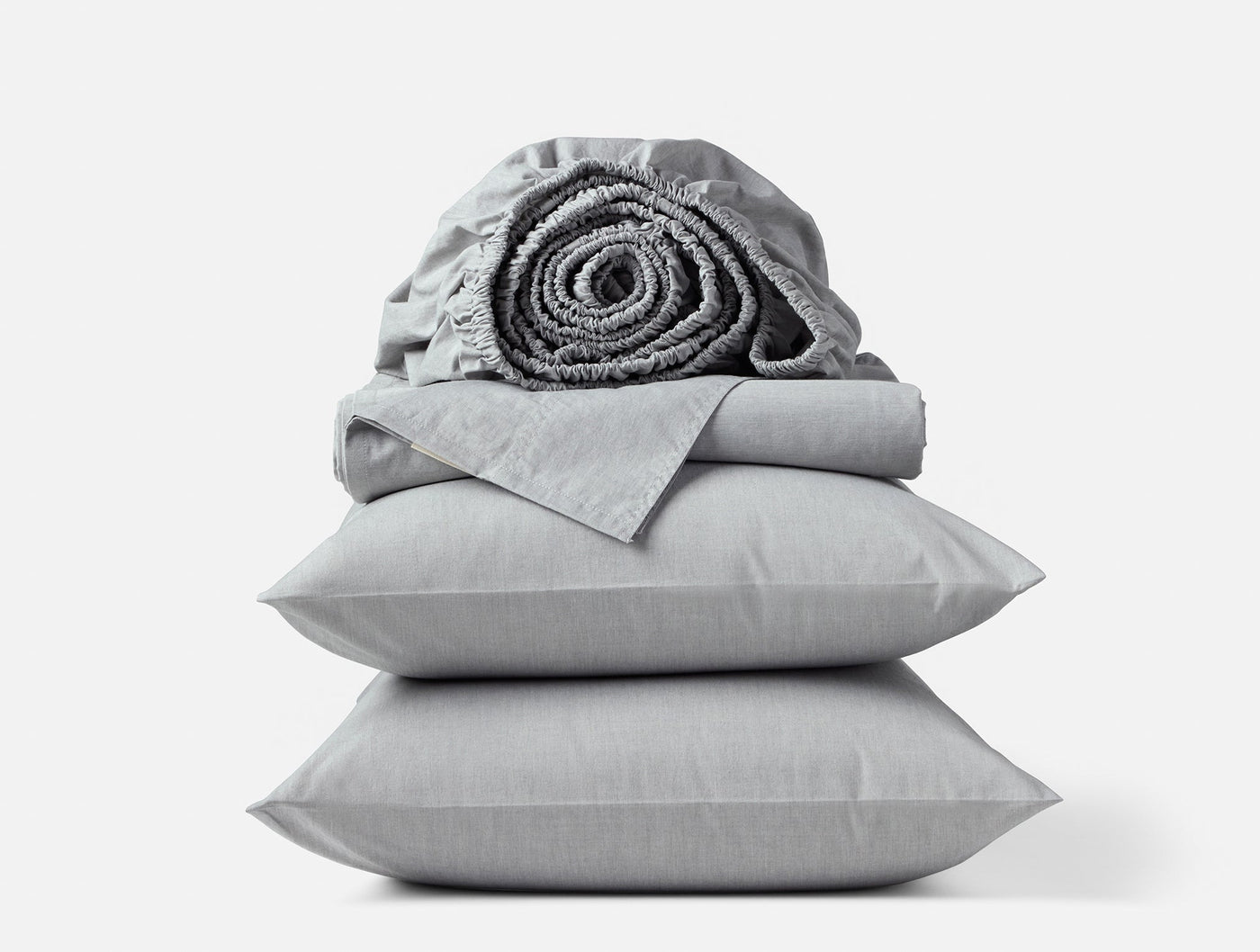 Dove grey crinkled percale sheet set stacked with rolled fitted sheet on top.