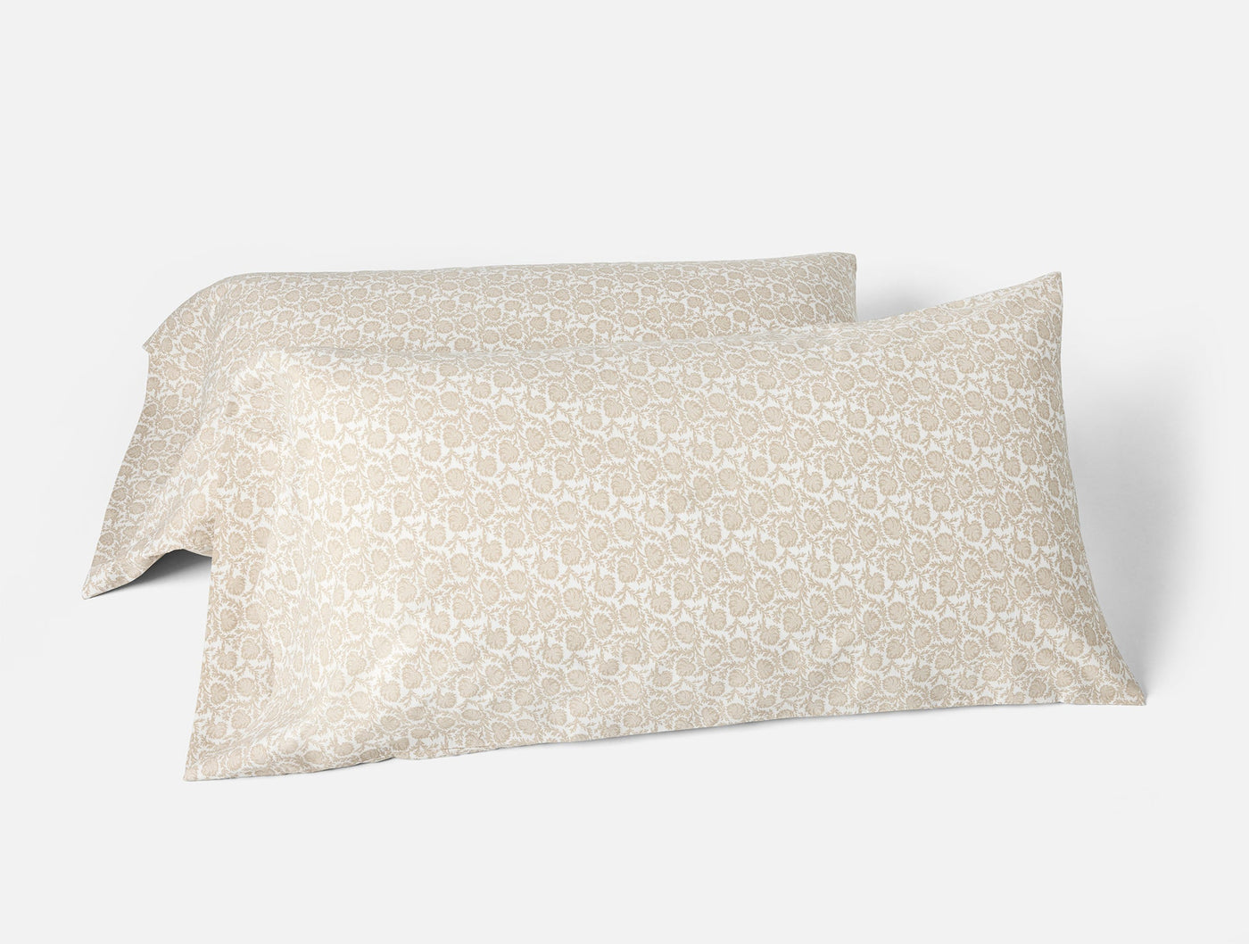 Close-up of two Coyuchi Print Percale pillowcases in warm taupe with tonal geometric pattern.