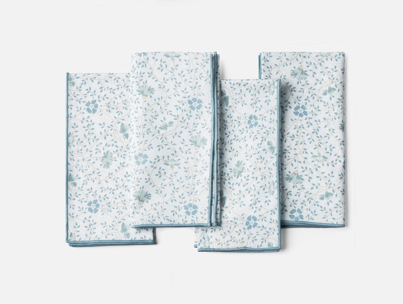 Coyuchi Print Percale napkin set, sky blue floral pattern on white, four napkins fanned flat.