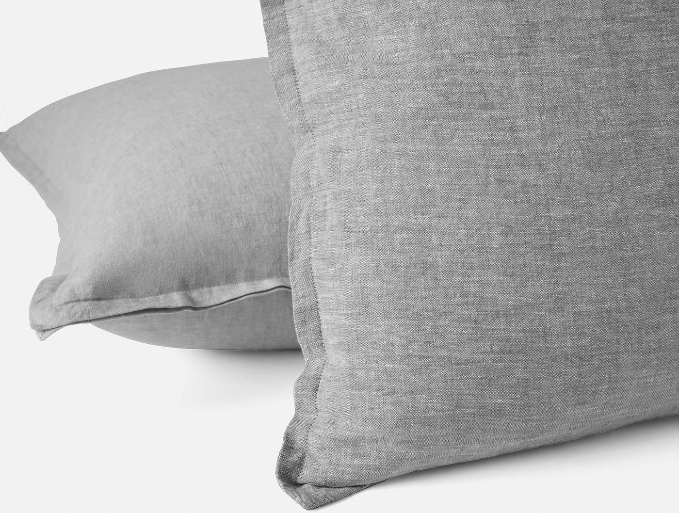 Close-up of Coyuchi Relaxed Linen pillow covers in grey, showing woven texture and flanged edges.