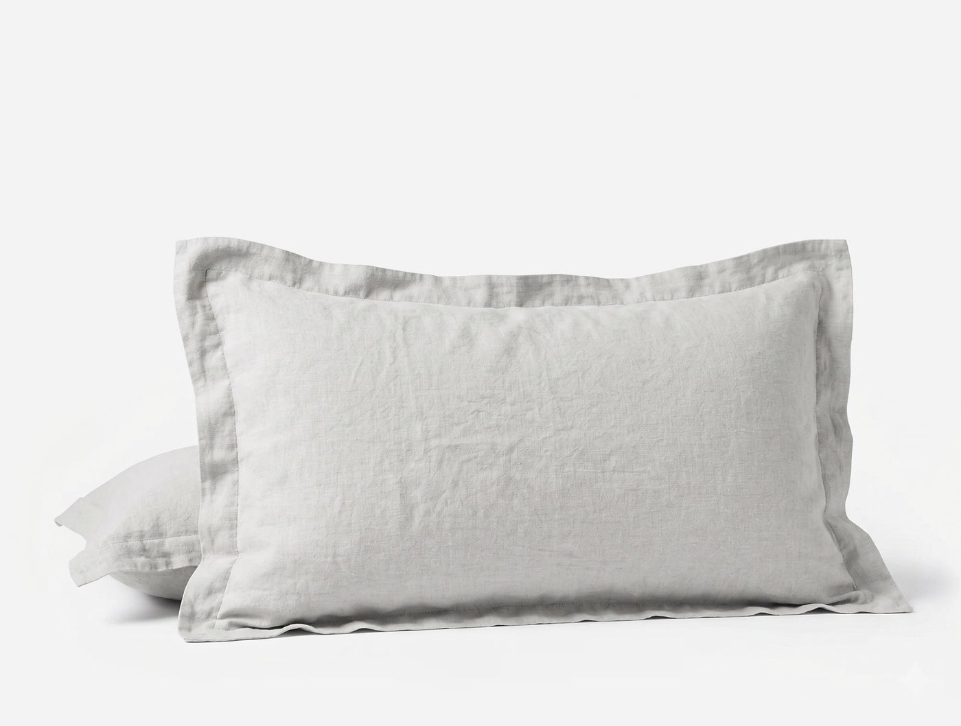Pair of white Coyuchi Relaxed Linen pillow shams stacked, showing flange edge detail.