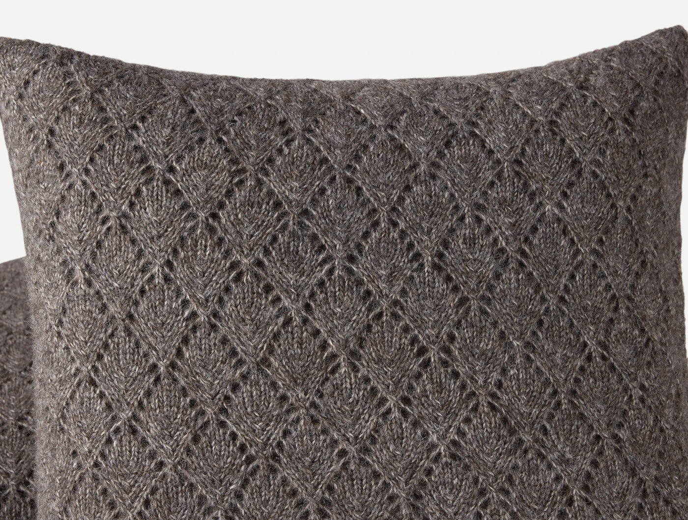 Close-up of Coyuchi Paracas pillow's charcoal alpaca knit with diamond lace pattern detail.