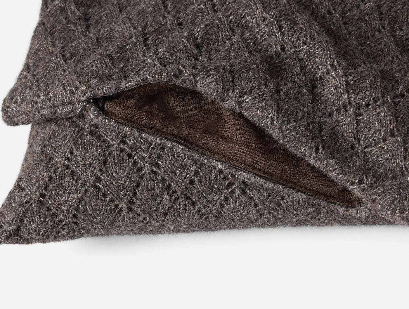 Close-up of Coyuchi Paracas pillow cover zipper closure, charcoal knit exterior with suede-like lining.