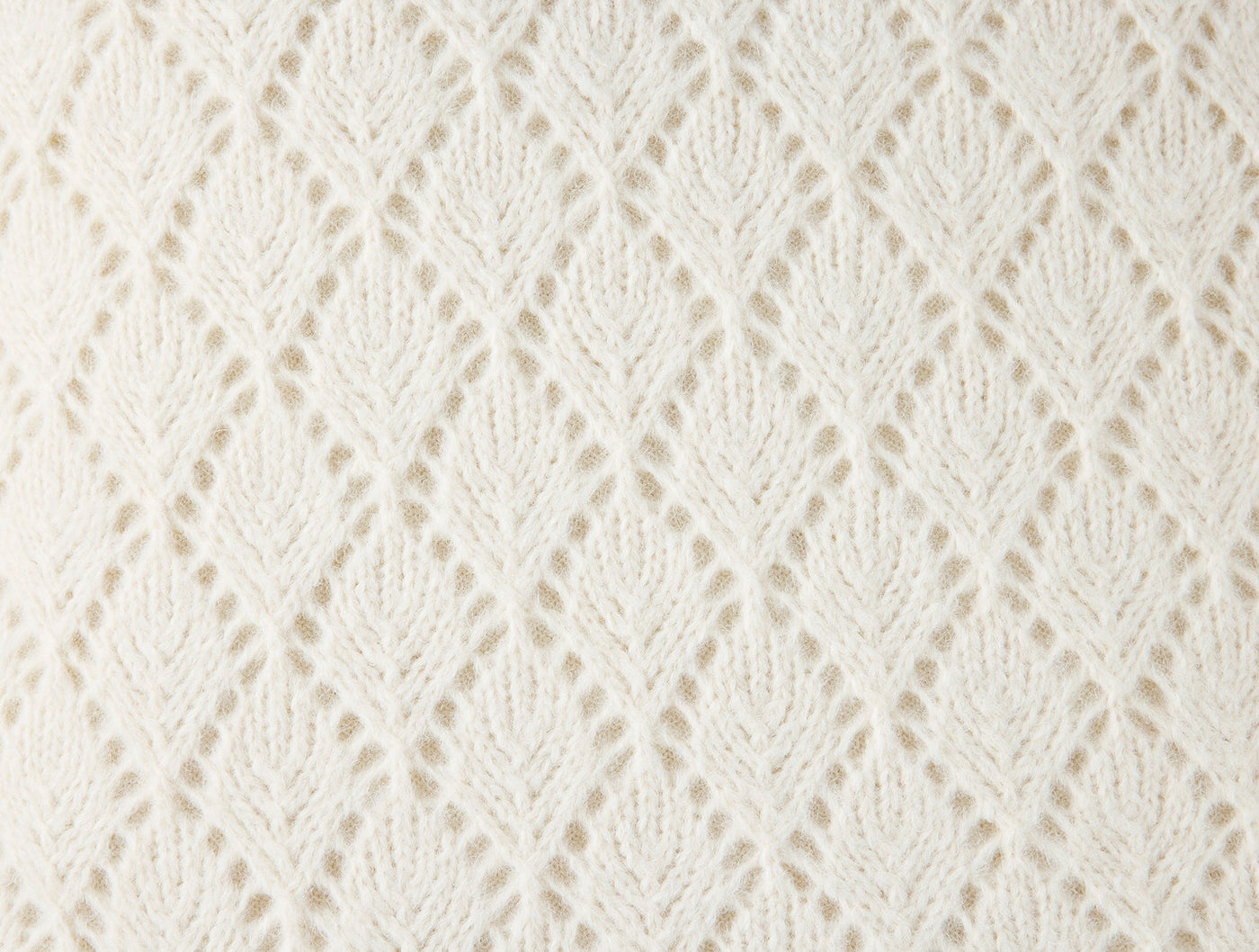 Close-up of ivory alpaca cotton openwork leaf knit pattern on Coyuchi Paracas pillow.