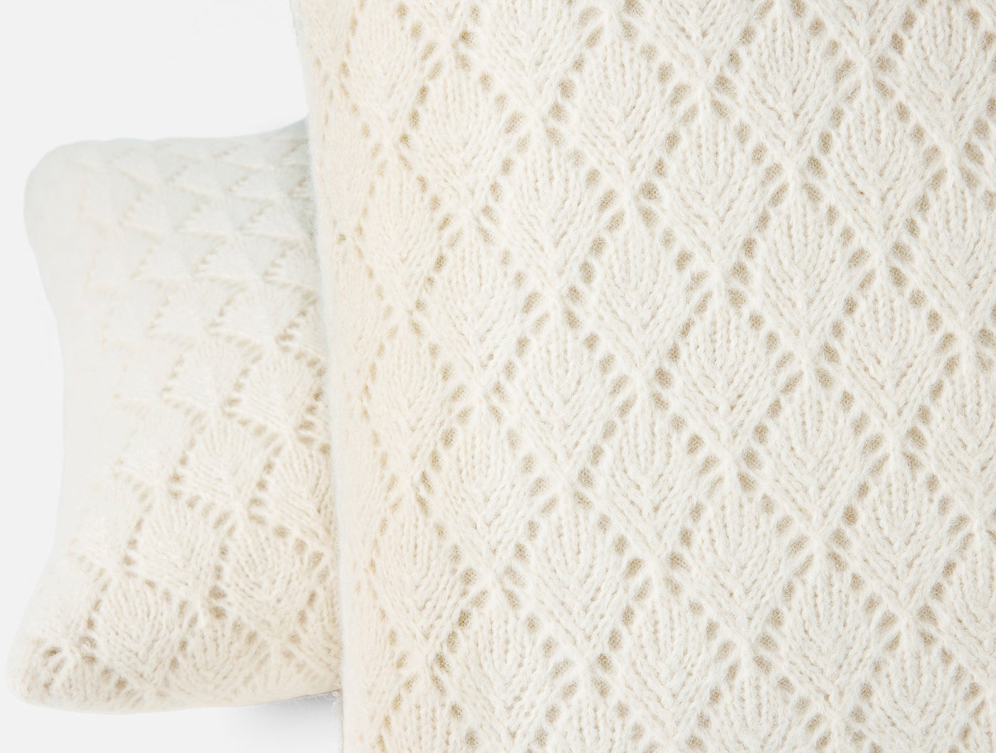 Close-up of ivory alpaca cotton open-knit leaf pattern on Paracas pillow cover.