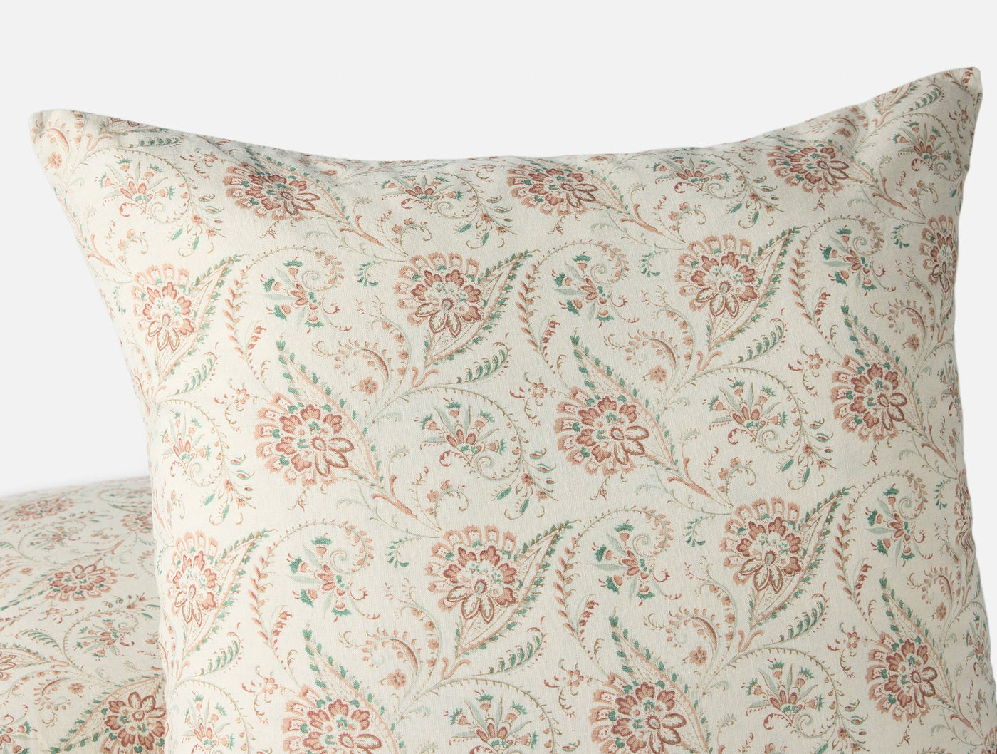Close-up of Coyuchi Ponderosa Print pillow cover in coral and sage floral block print.