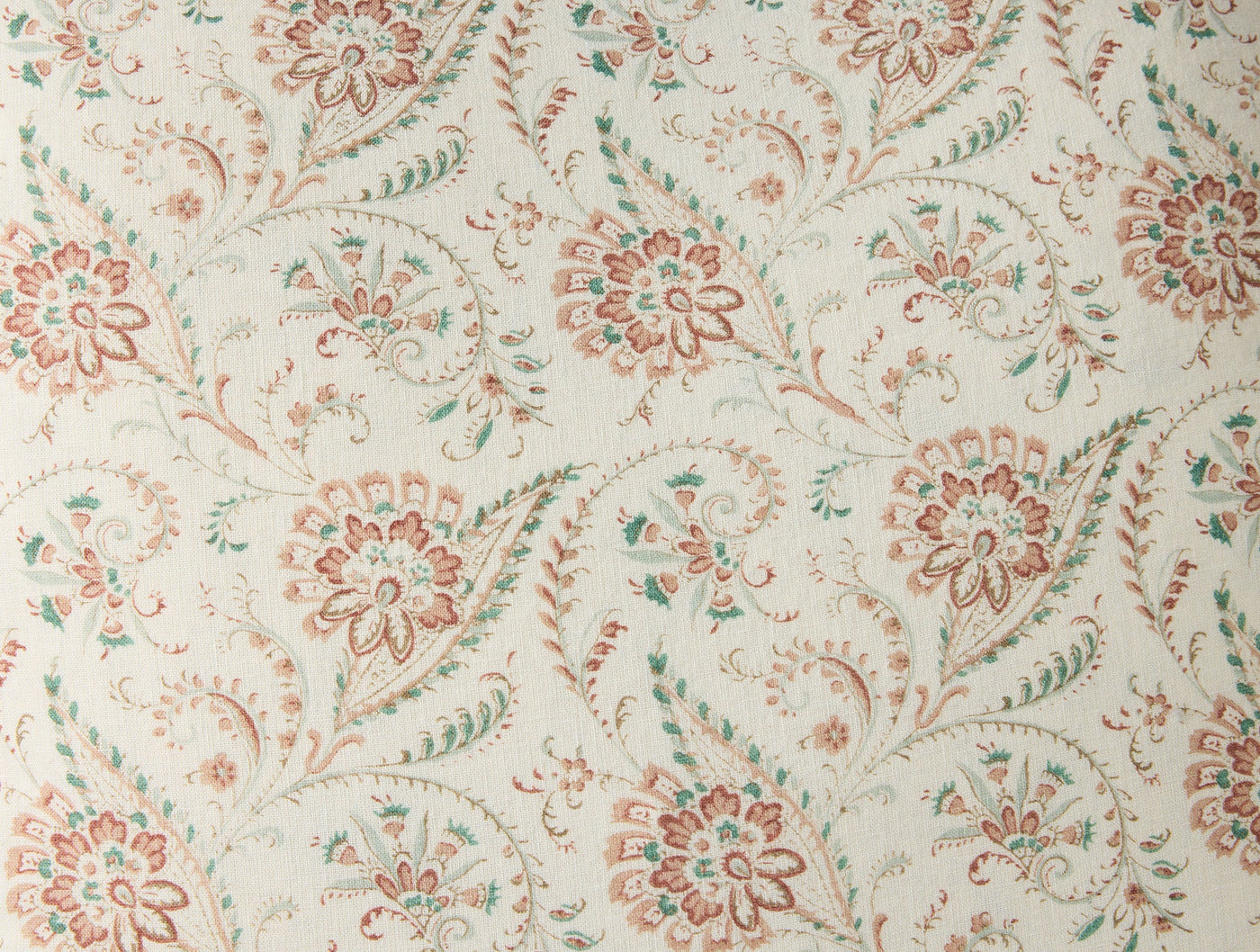 Close-up of Coyuchi Ponderosa Print pillow in terracotta and sage floral pattern on ivory.
