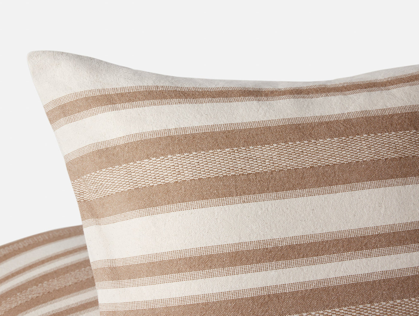 Close-up of Coyuchi Serrano pillow corner showing woven camel and ivory stripe detail.