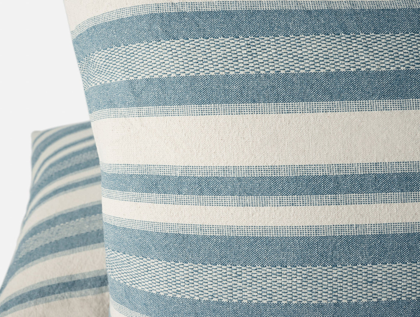 Close-up of Coyuchi Serrano pillow's woven blue and ivory horizontal stripe texture.