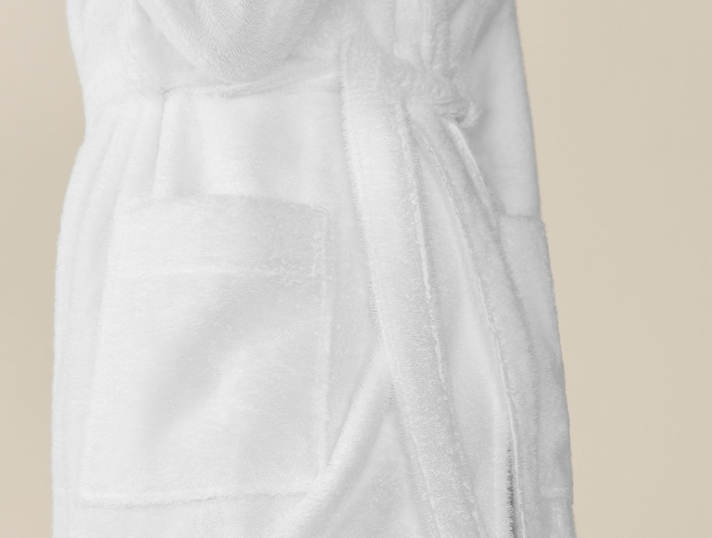 Close-up of white terry Coyuchi Cloud Loom robe pocket and tie belt detail.