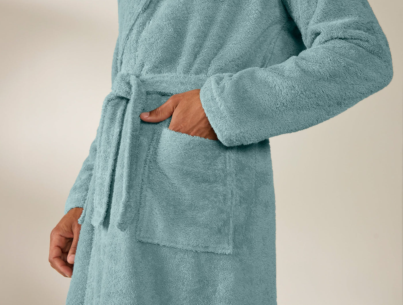 Close-up of Coyuchi Cloud Loom robe pocket and tie detail in dusty teal terry.