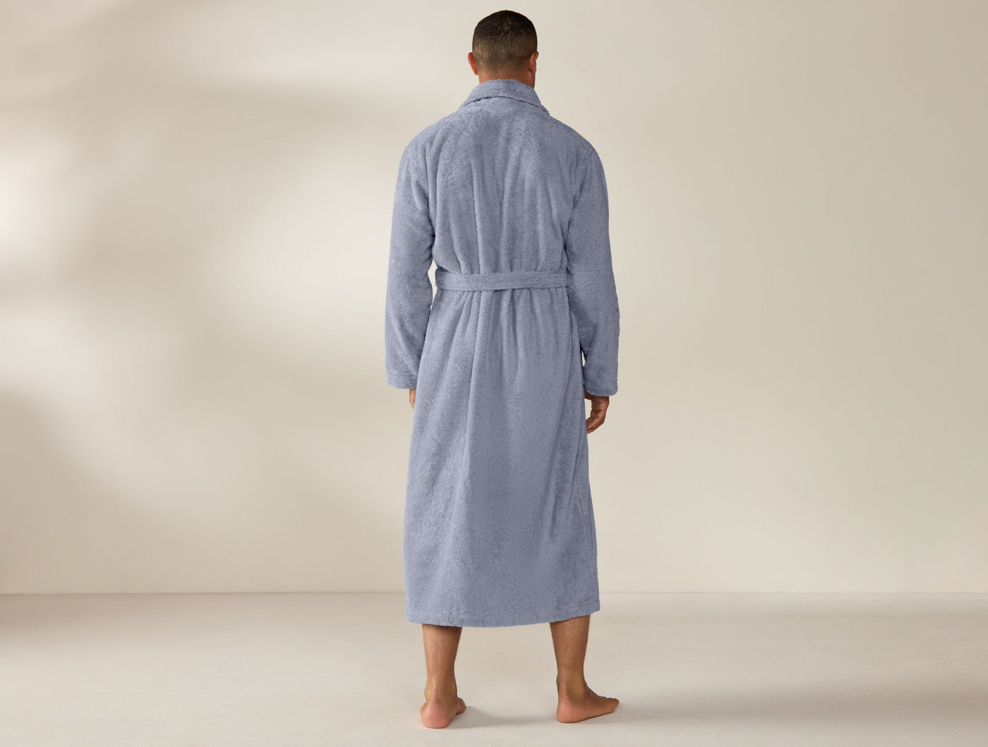 Back view of Coyuchi Cloud Loom unisex robe in slate blue, full-length terry cloth with tie belt.