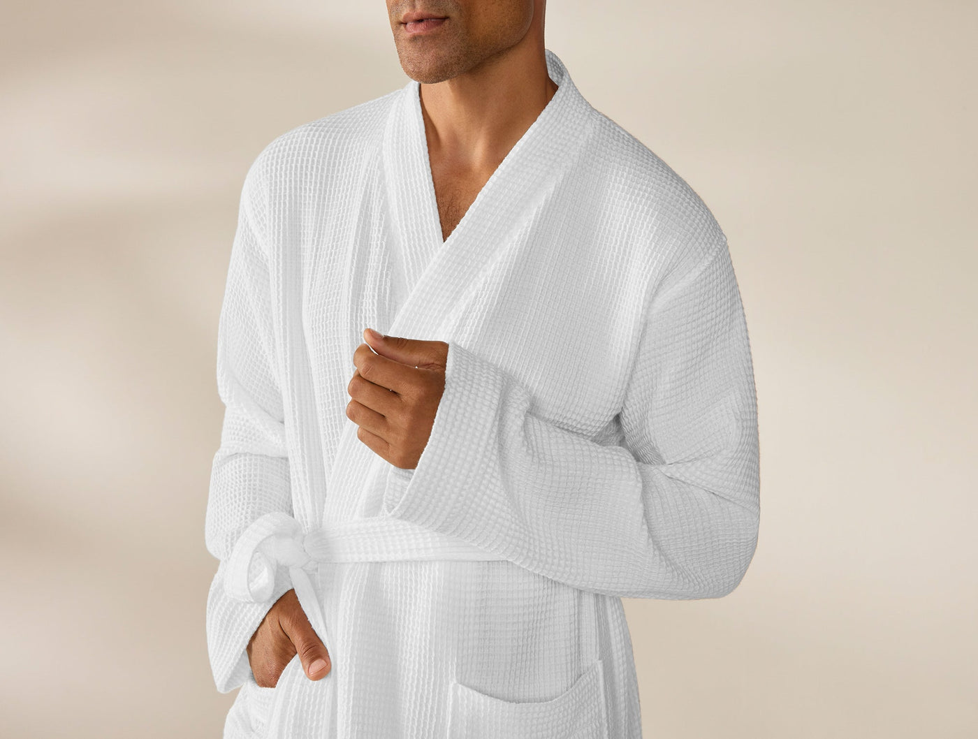 Close-up of Coyuchi waffle robe in white, showing chest, collar, and cuff detail on male model.
