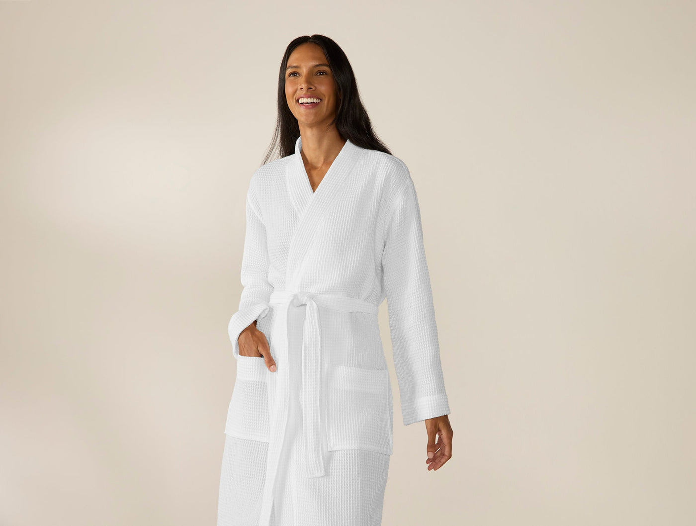 Coyuchi Unisex Waffle Robe in white, worn by smiling model, showing full-length fit.