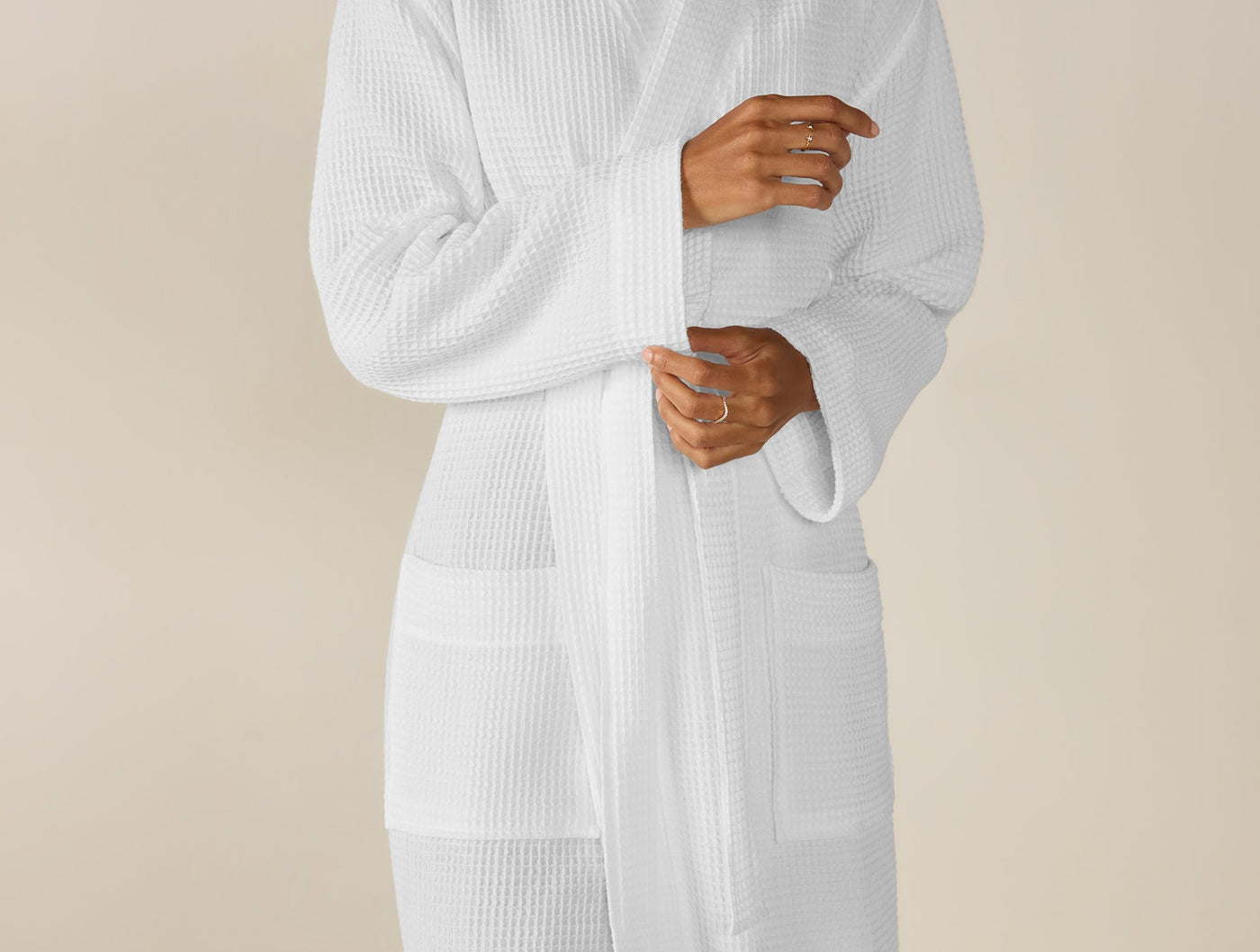 Close-up of Coyuchi waffle-knit robe in white, showing textured fabric and belt detail.