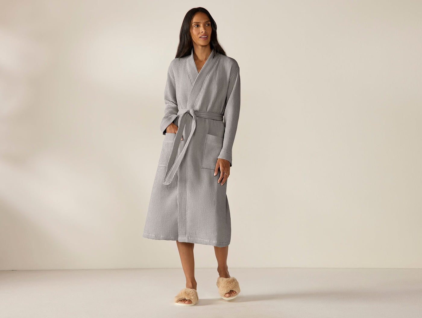 Model wearing Coyuchi Unisex Waffle Robe in grey, full-length front view, belted.