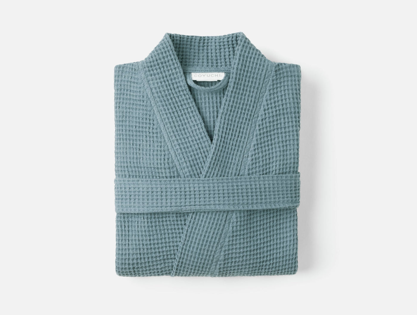 Coyuchi Unisex Waffle Robe folded flat, showing slate blue waffle-knit texture and kimono collar.