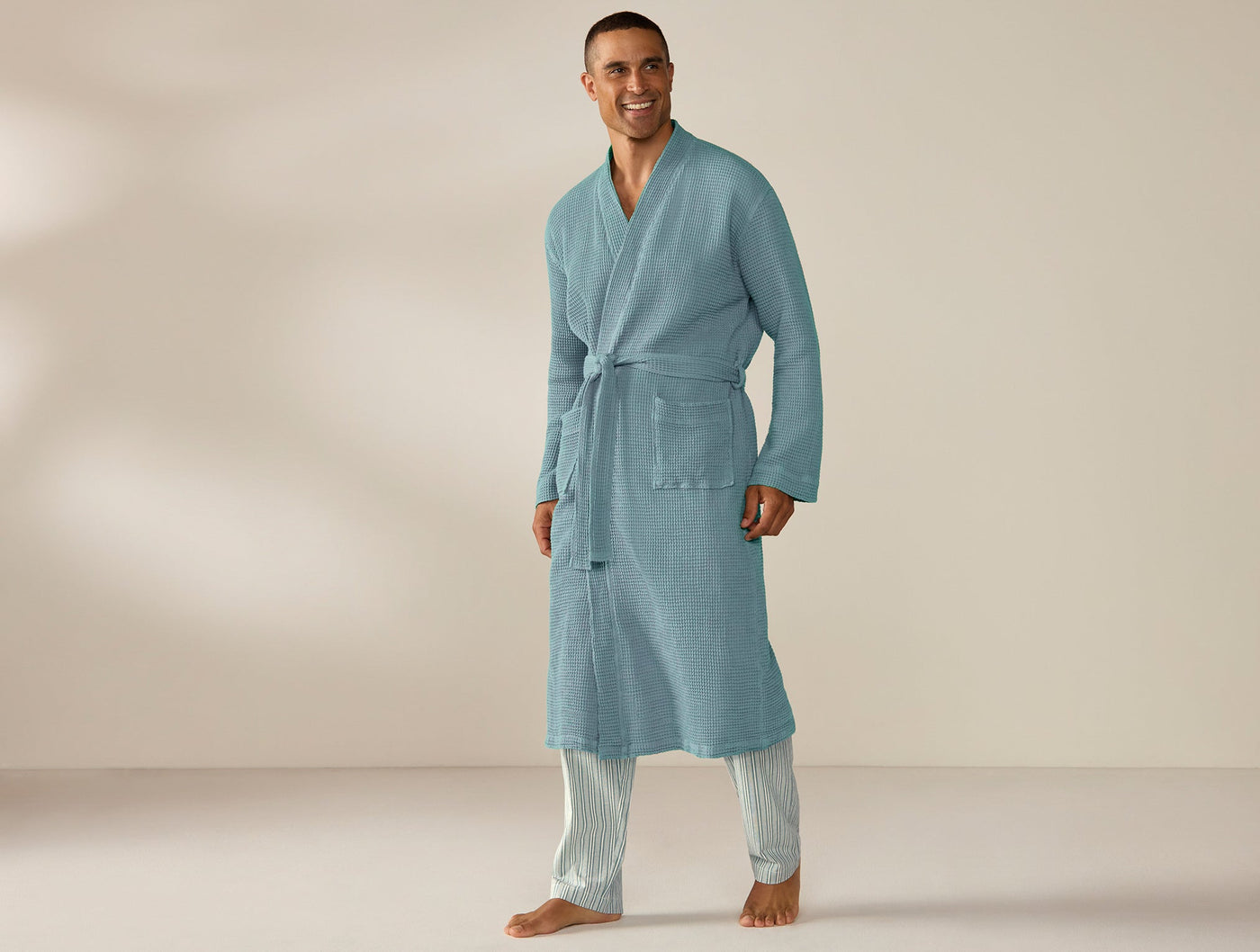 Coyuchi Unisex Waffle Robe in sky blue, belted, full-length view on male model.