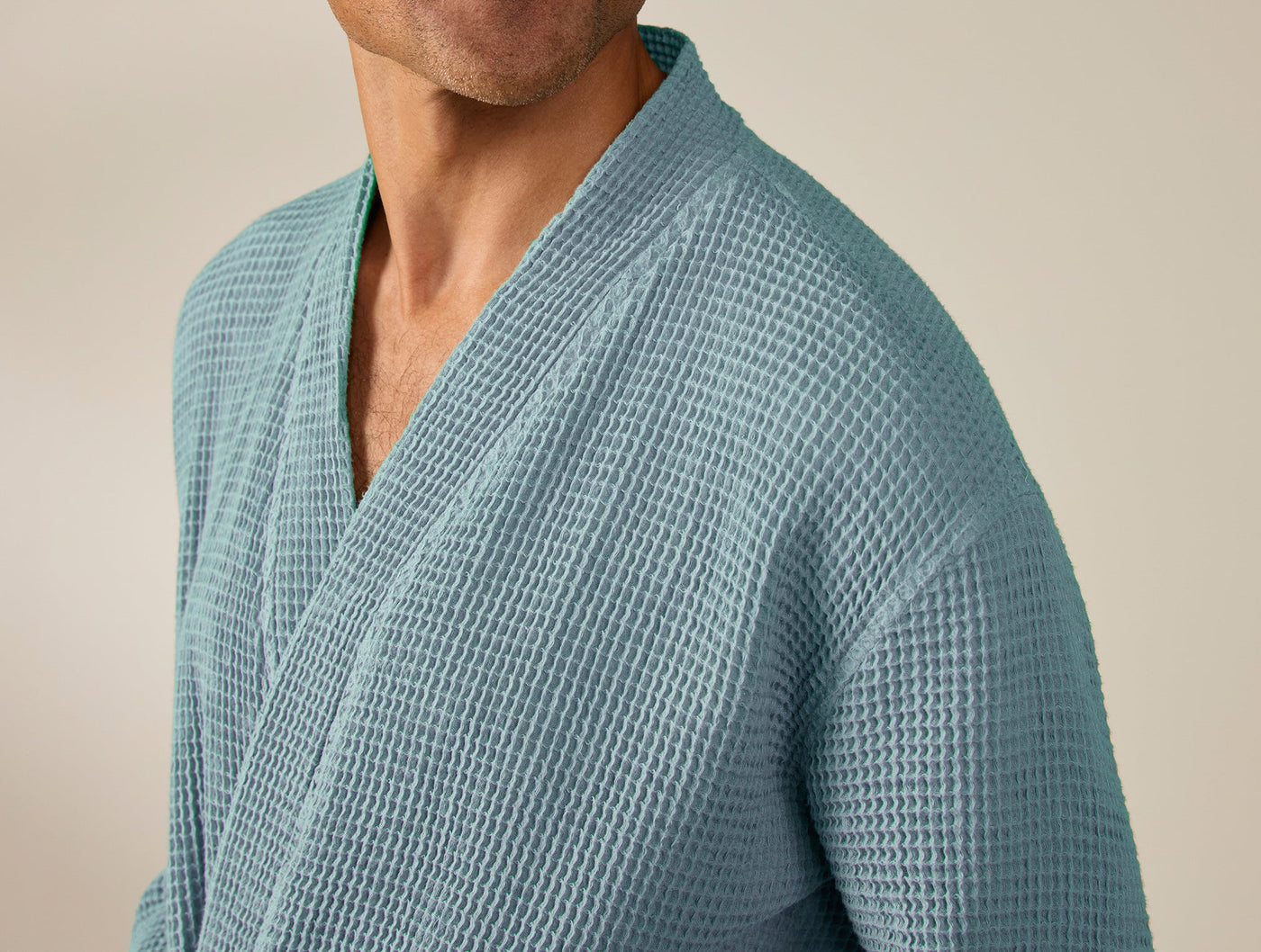 Close-up of Coyuchi waffle-knit robe in teal, showing lapel and textured weave detail.