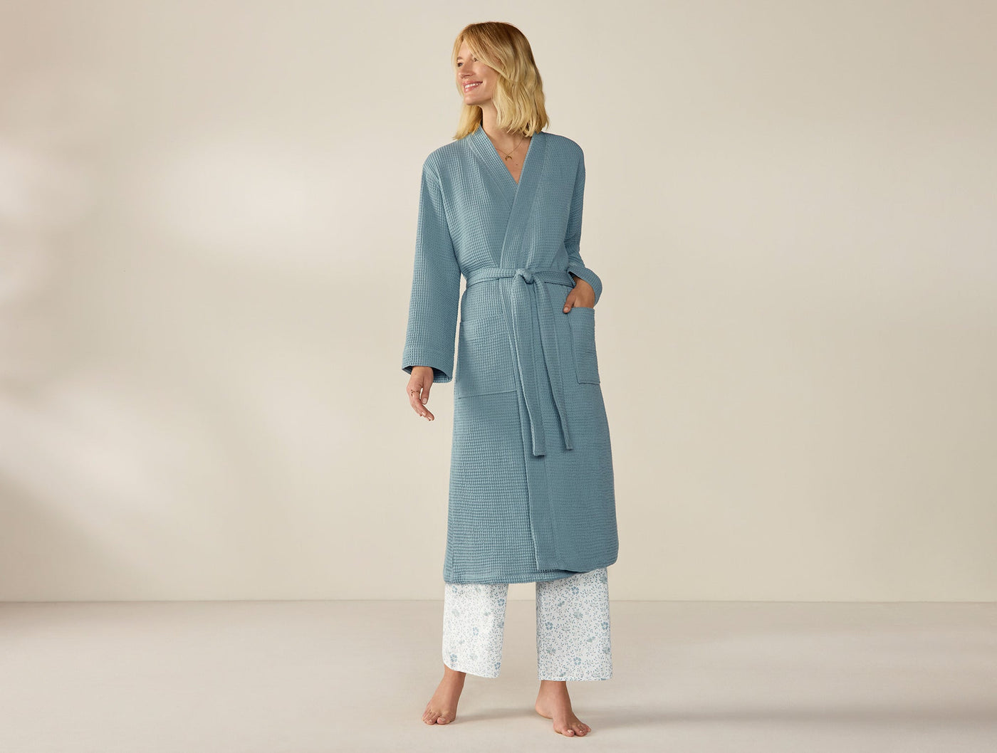 Coyuchi Unisex Waffle Robe in slate blue, full-length styled view on model with belt tied.
