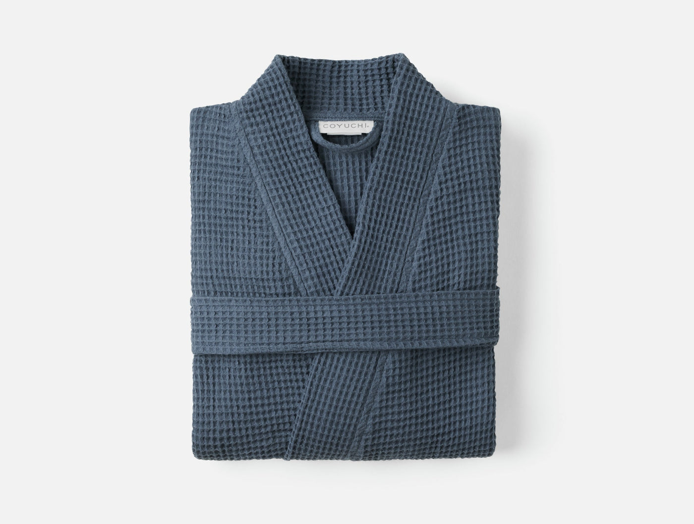 Coyuchi Unisex Waffle Robe folded flat, slate blue waffle-knit texture visible.