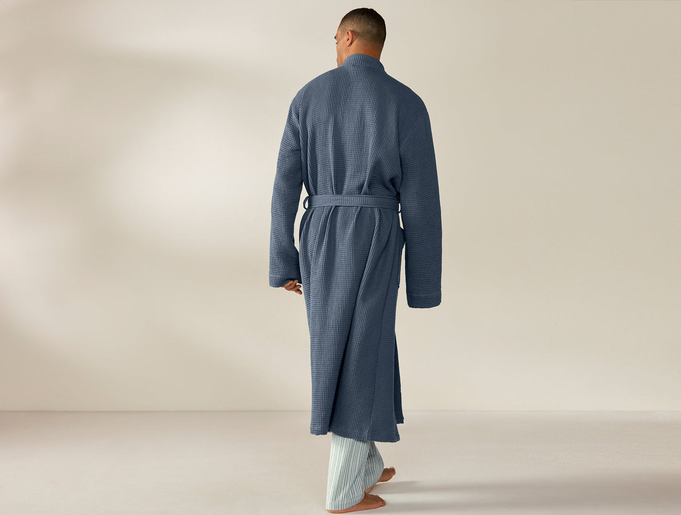 Back view of Coyuchi slate blue waffle-knit robe with belted waist, full-length styling.