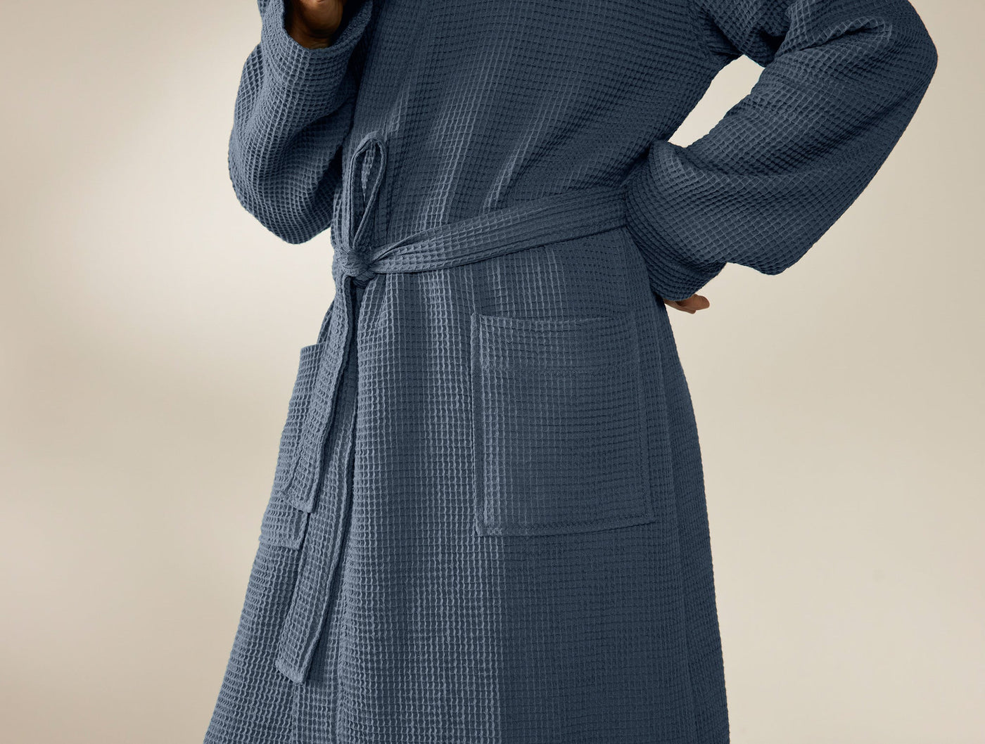 Close-up of Coyuchi Unisex Waffle Robe in slate blue, showing belted waist and patch pockets.