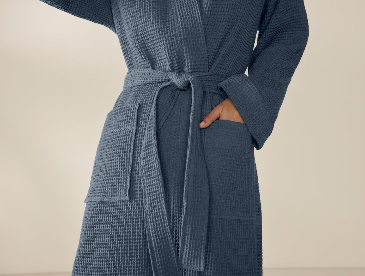 Close-up of Coyuchi Unisex Waffle Robe in slate blue, showing belted waist and pocket detail.