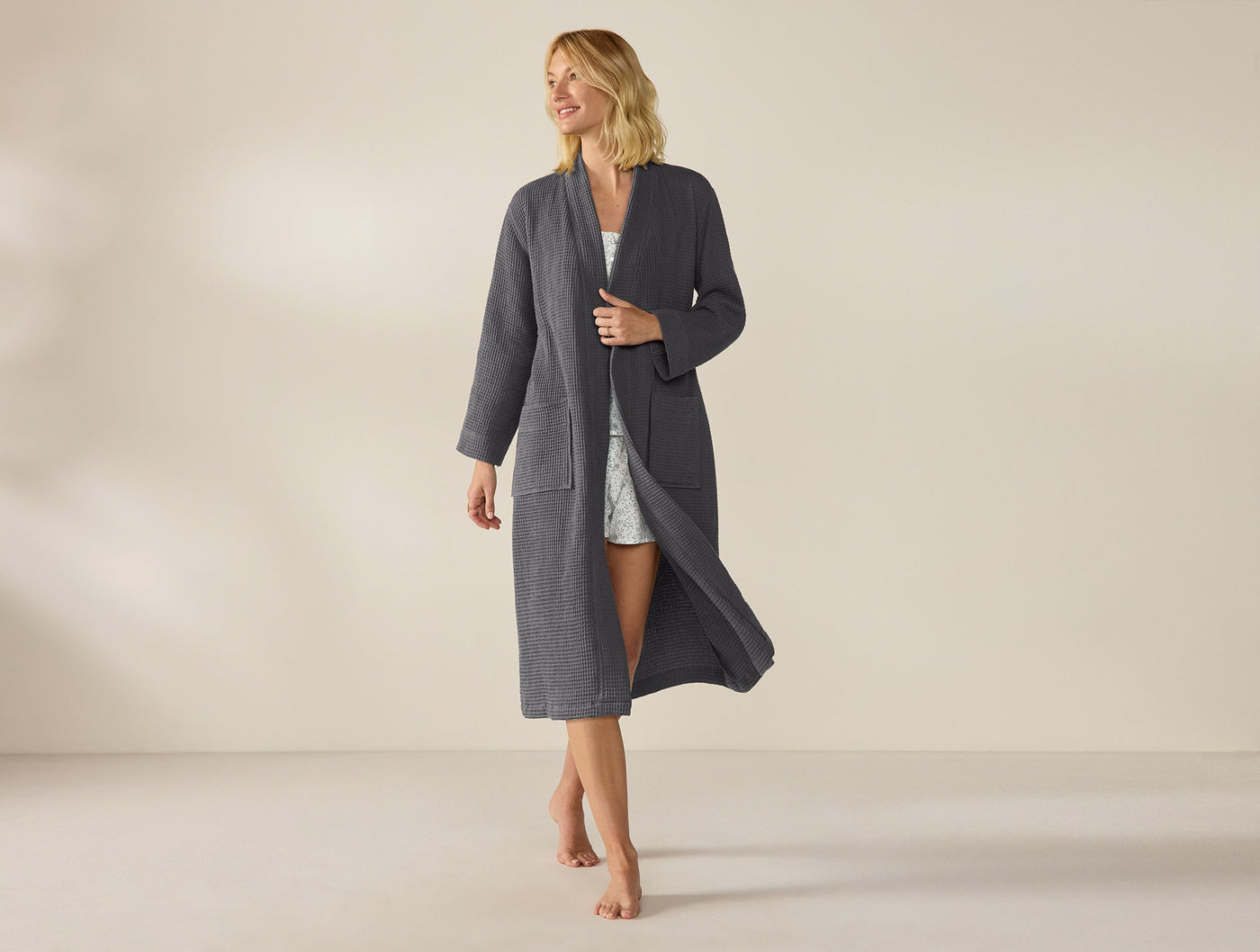 Model wearing full-length Coyuchi slate waffle robe, open front, floor-length hem.