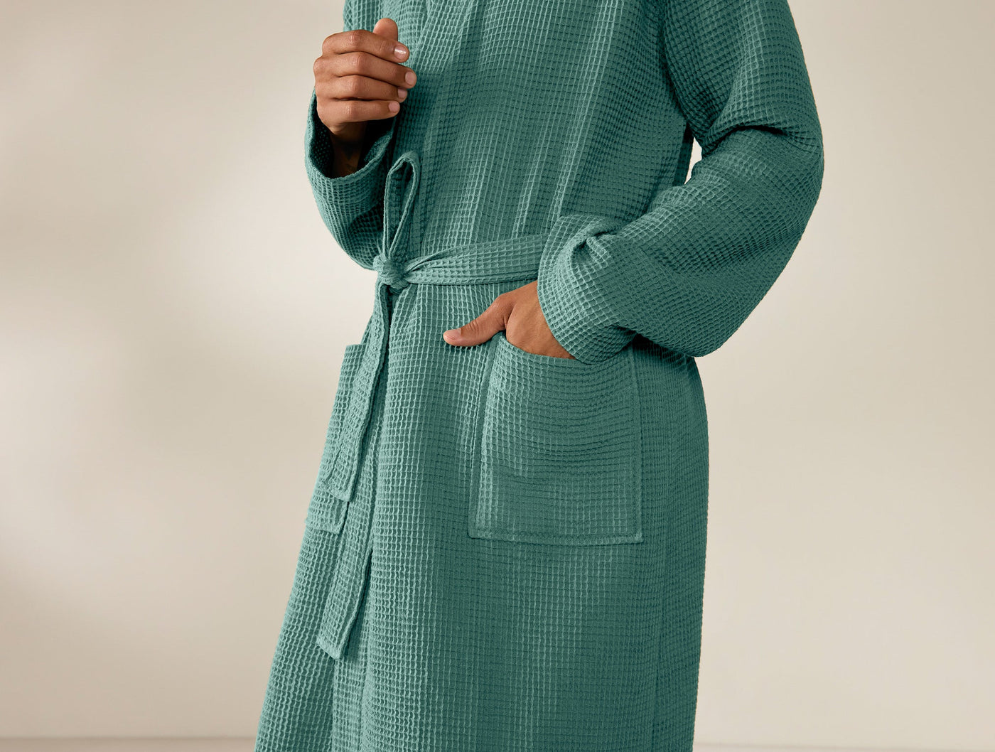 Teal waffle-knit robe with tied belt, patch pocket detail, worn by a model.