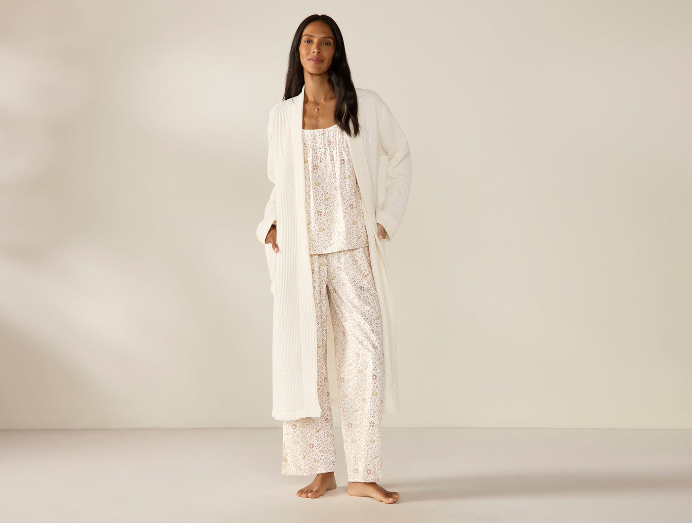 Coyuchi Unisex Waffle Robe in ivory, styled open over floral pajama set on model.
