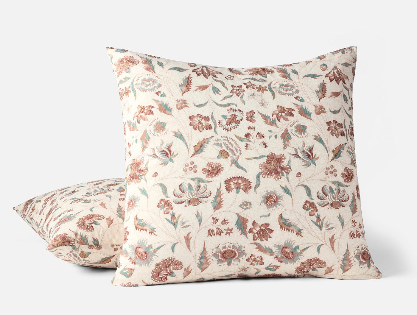 Close-up of two Coyuchi Viola Print shams stacked, ivory with dusty rose floral pattern.