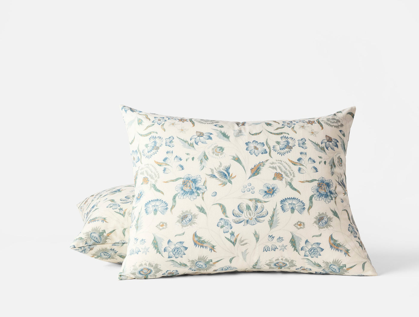 Two Coyuchi Viola Print shams stacked, ivory with blue-green floral pattern.