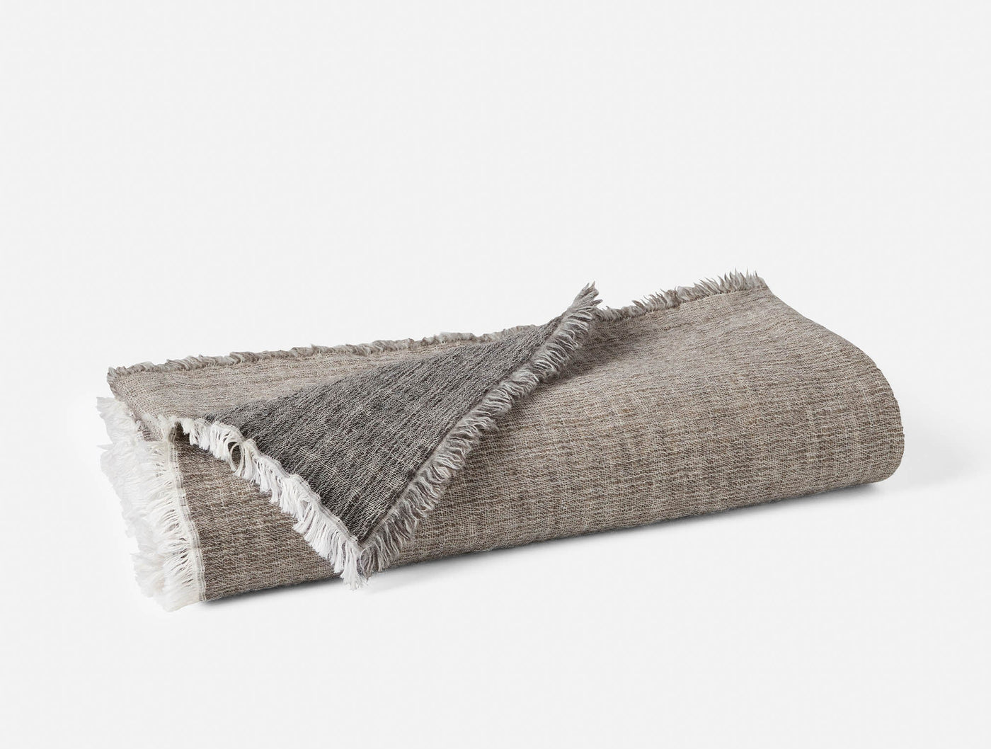 Folded throw showing contrast between taupe herringbone face and charcoal reverse, with fringe trim.