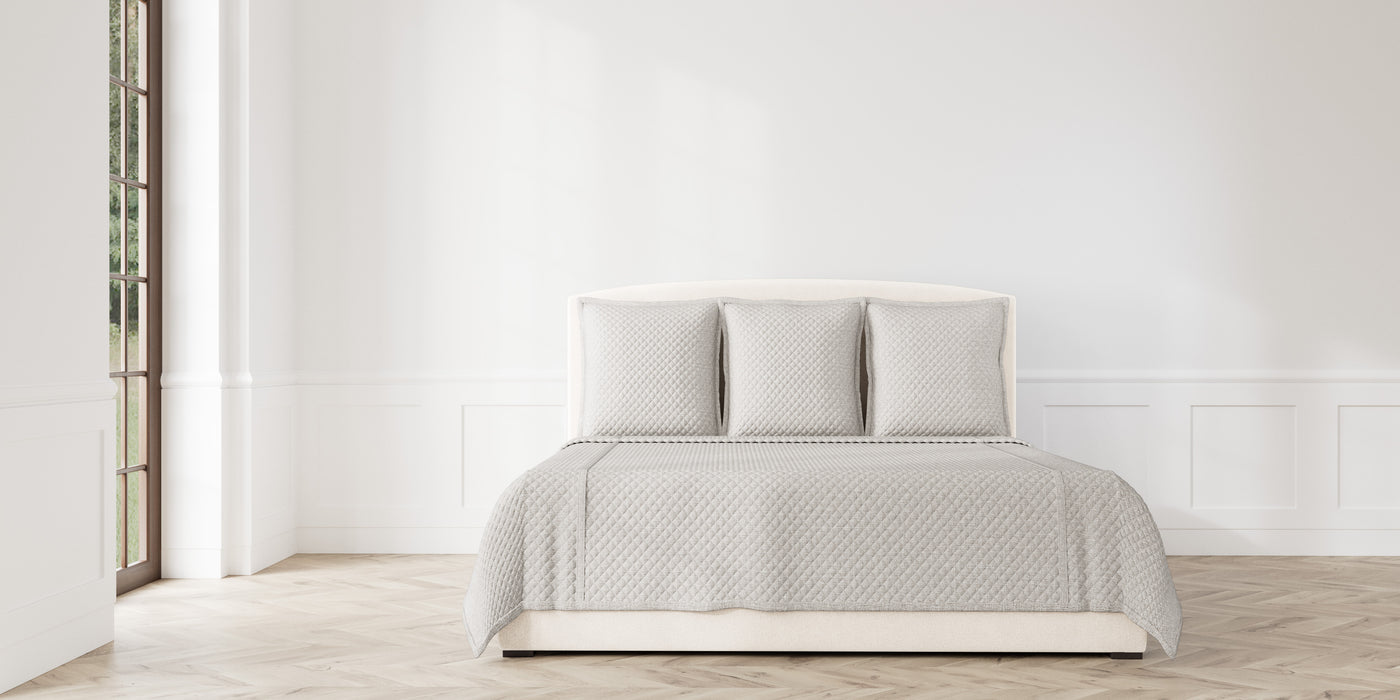 Ann Gish Faux Flax coverlet set styled on bed in ivory with subtle quilted texture.