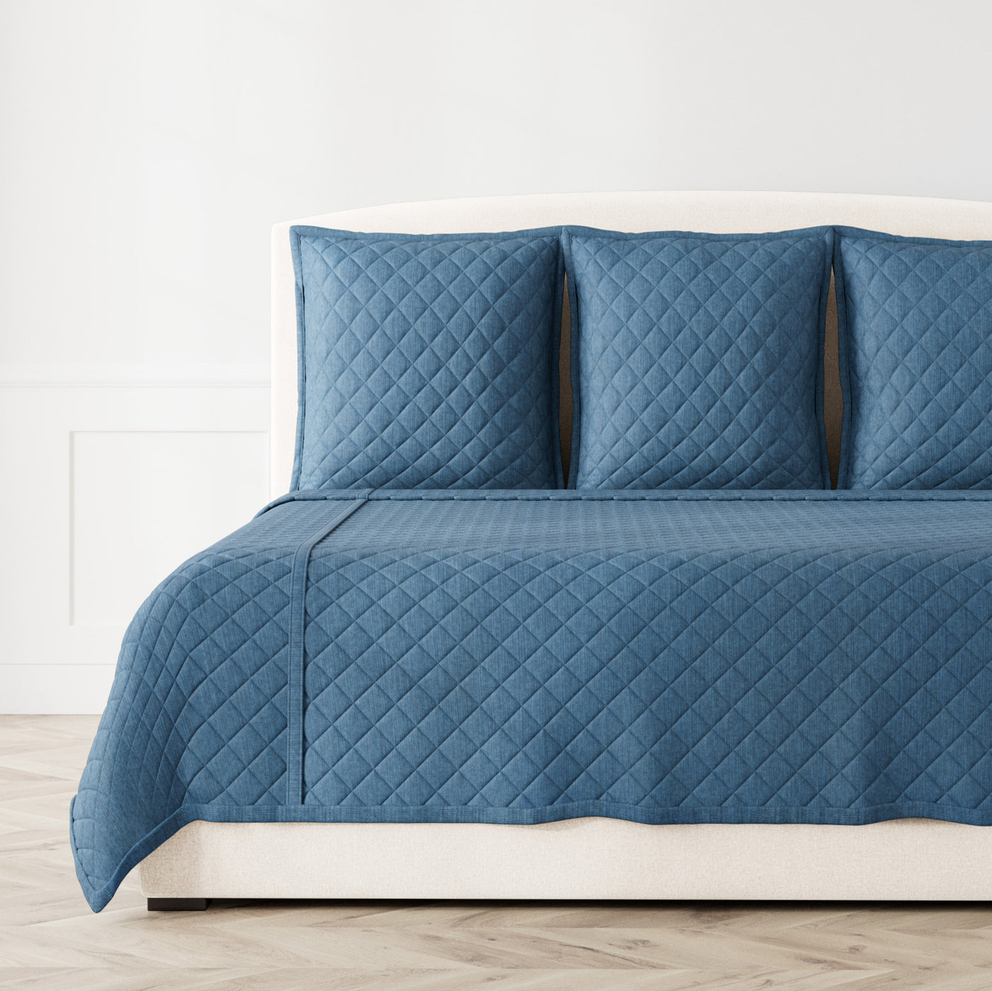 Ann Gish Faux Linen Coverlet Set in slate blue with diamond quilting on styled bed.