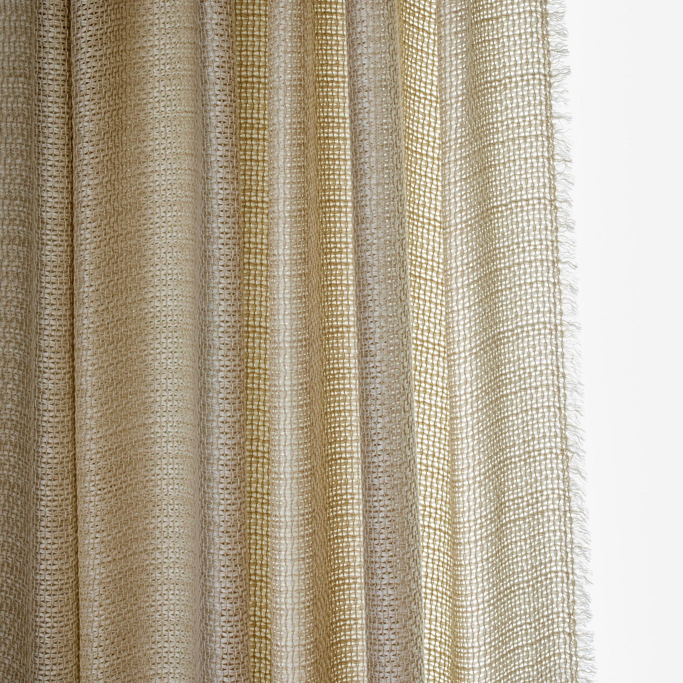 Close-up of Ann Gish Ficelle curtain panel showing champagne open-weave texture with fringe edge.