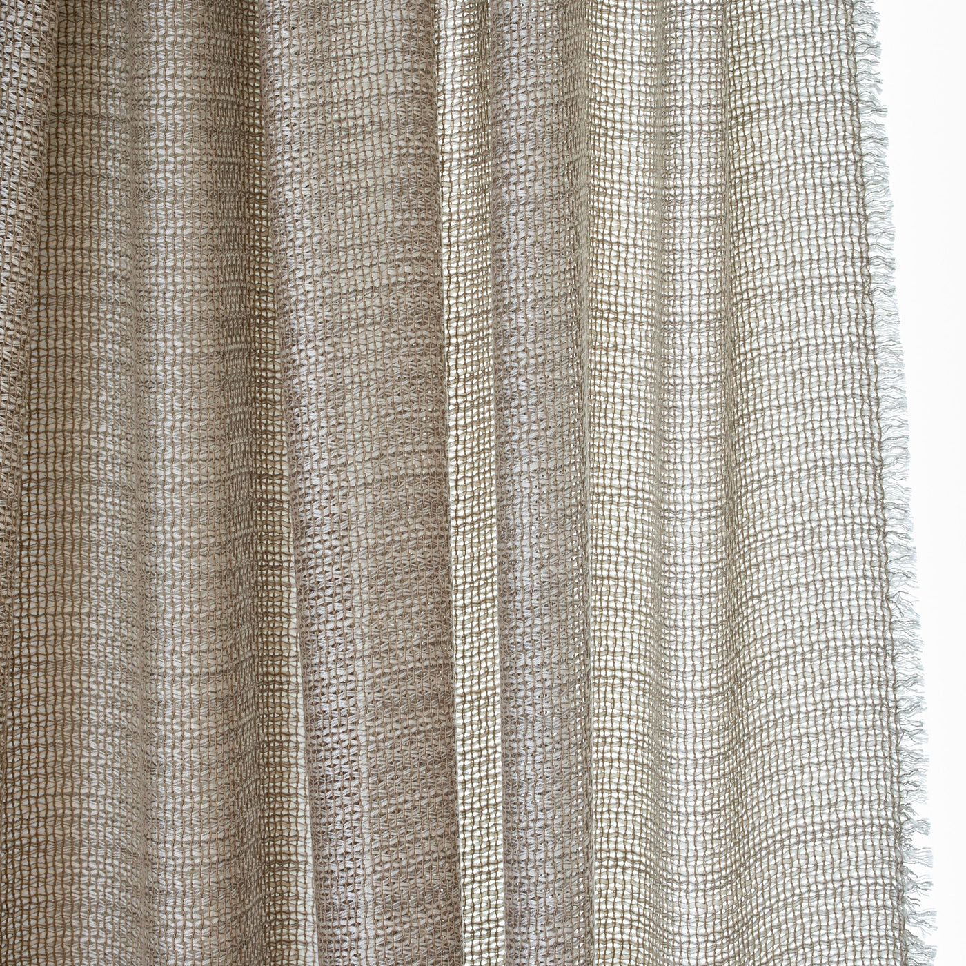 Close-up of Ann Gish Ficelle curtain panel in natural linen, showing open loose weave and frayed hem.