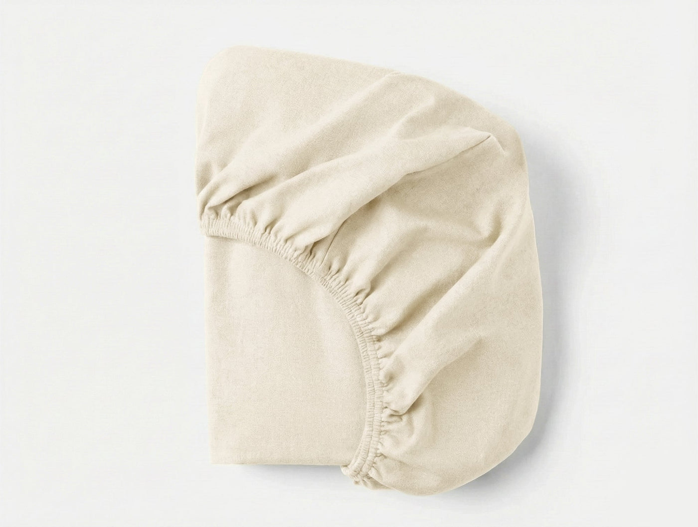 Coyuchi Cloud Brushed Flannel fitted sheet in ivory, elasticated corners visible.