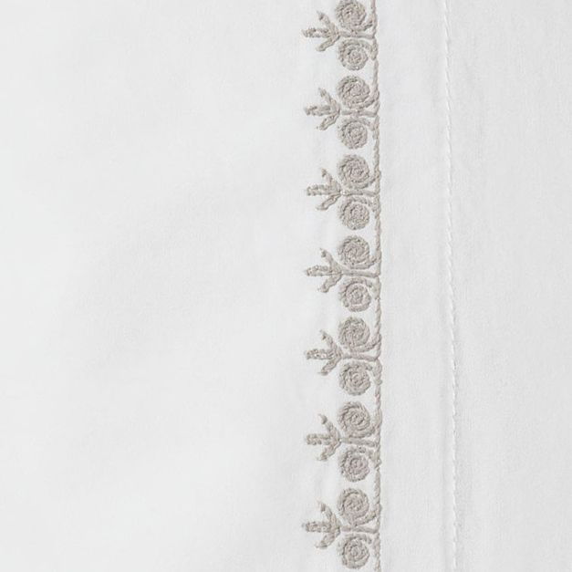 Close-up of taupe floral embroidered border on white Coyuchi Floret pillowcase.