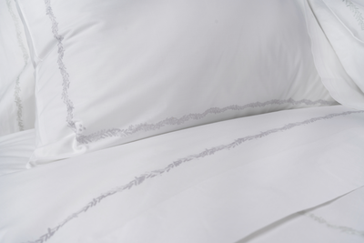 Henry Handwork Foglia white cotton bedding with delicate grey embroidered leaf trim detail.