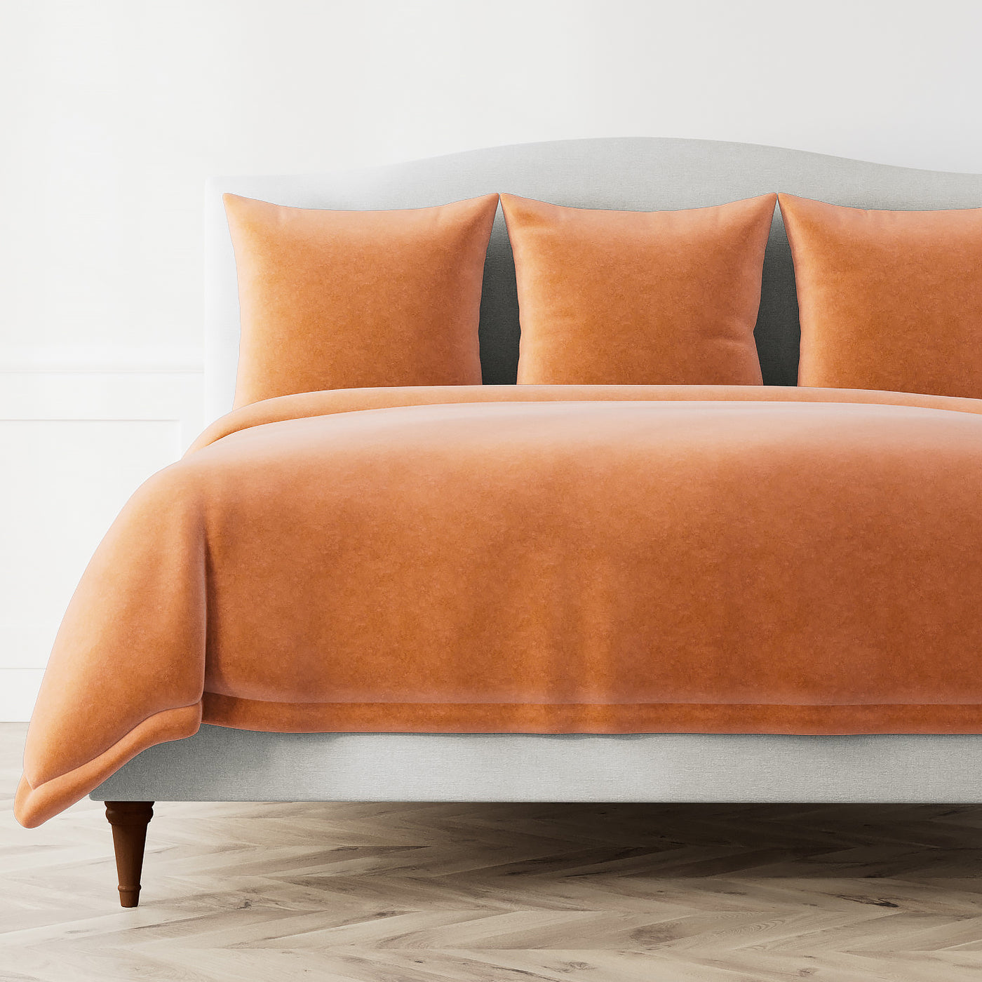 Fresco Velvet duvet cover and shams in tangerine velvet styled on a bed.