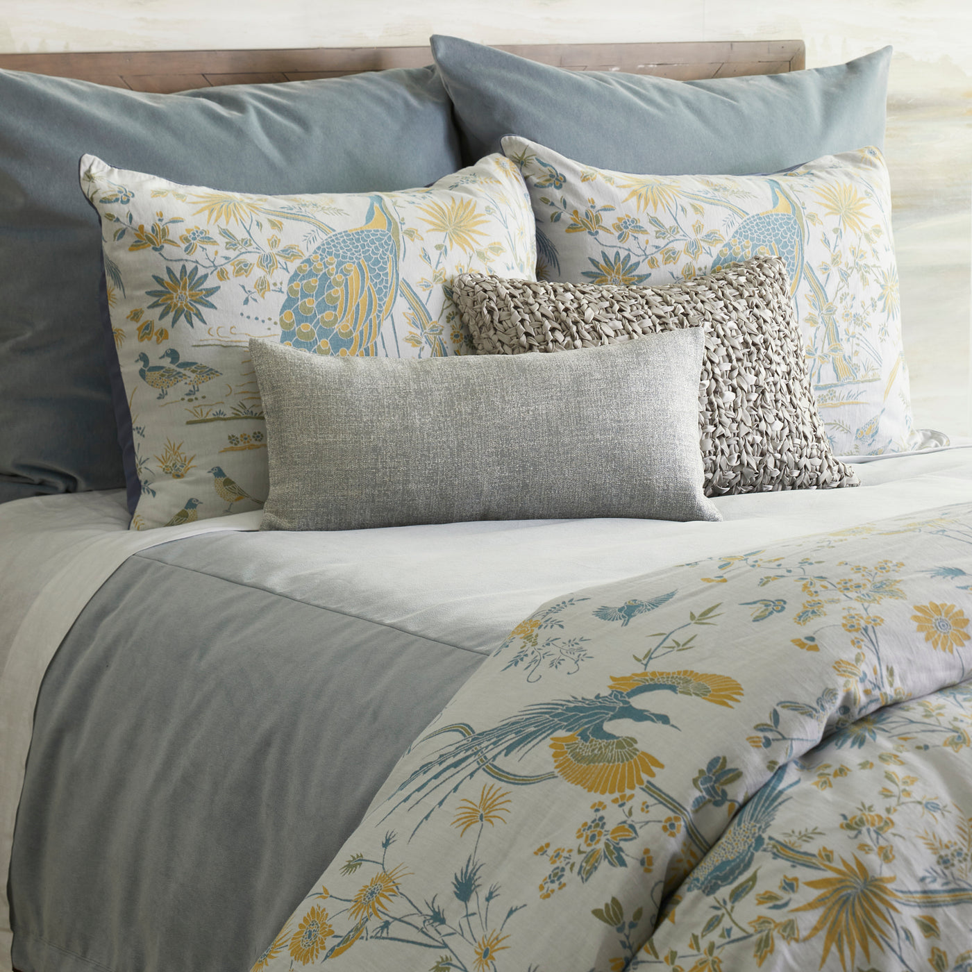 Ann Gish Fresco Velvet duvet styled on bed with floral bird print in sage, gold, and sky blue.
