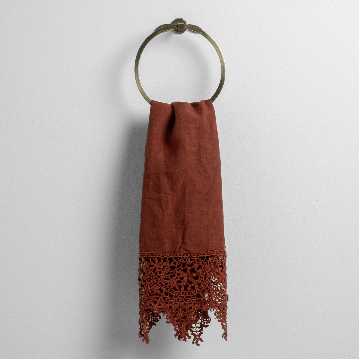 Autumn guest towel draped on brass ring, showing intricate floral crochet lace hem detail.